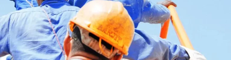 men from behind with safety helmet climbing a ladder